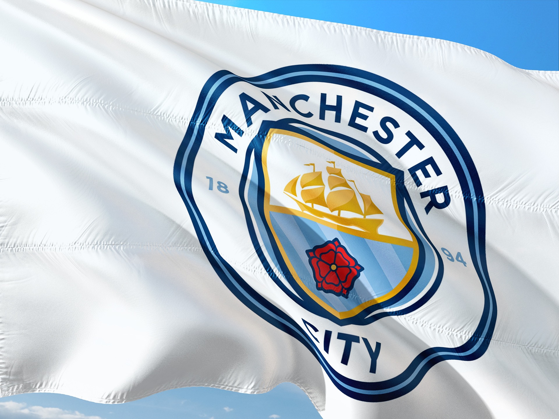 Manchester City crest on a white flag waving in the wind