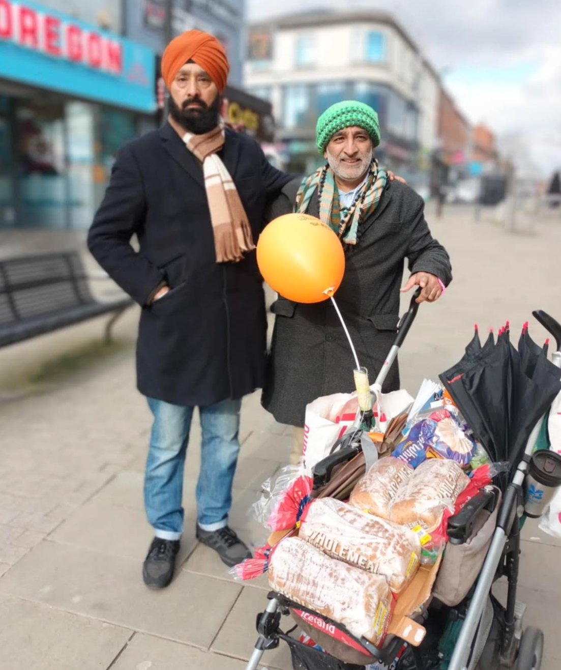 In the picture Muhammed is with a member of the public and with his pram loaded with food for the homeless.